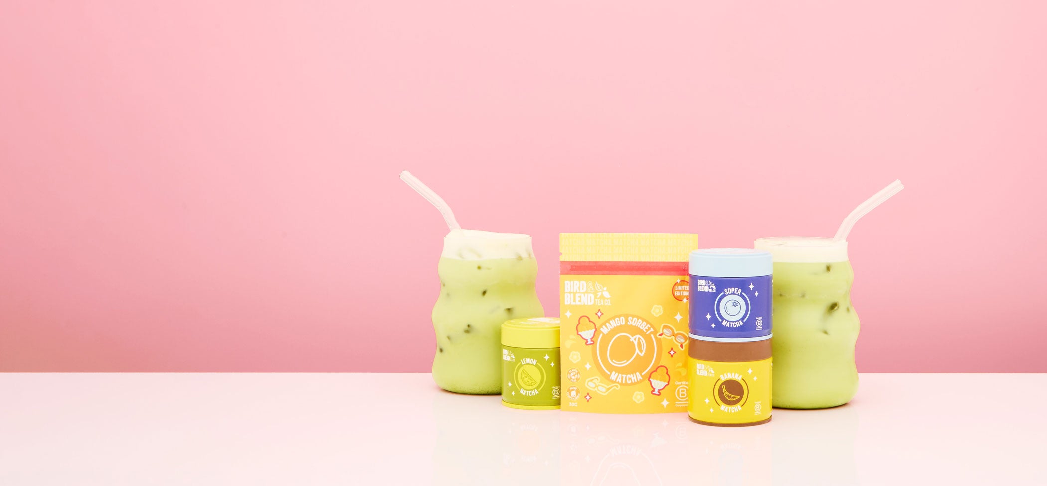 fruity matcha tea powder in tins and pouch & iced matcha latte desktop background