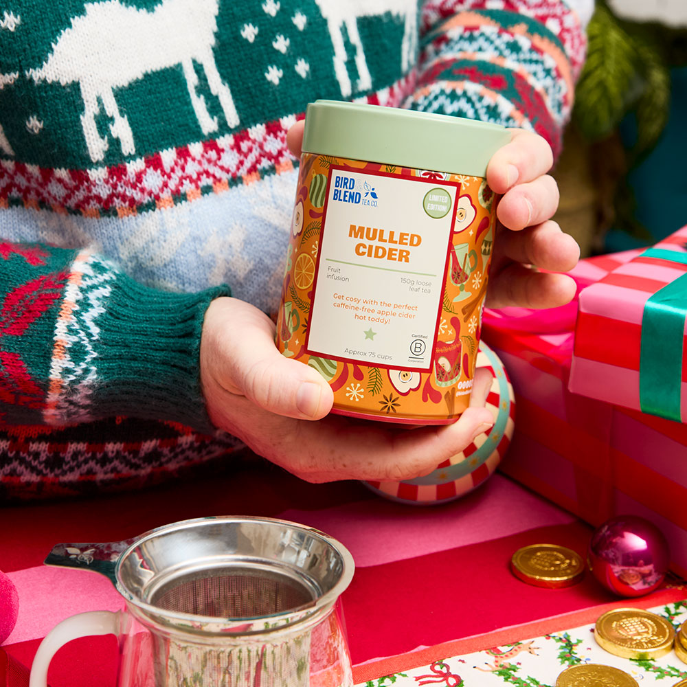 person holding mulled cider fruit gift tea tin