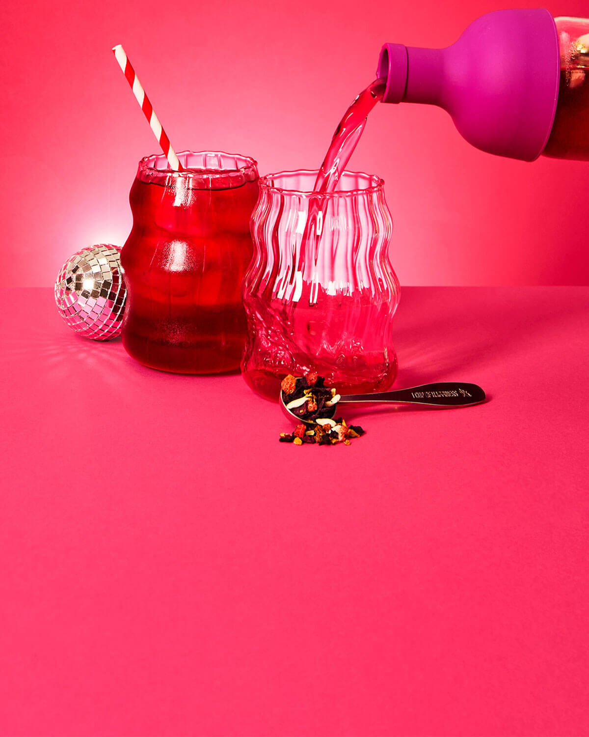 plum purple cold brew tea bottle pouring bubble gum pop! tea into cup with ice and spoon filled with loose leaf tea