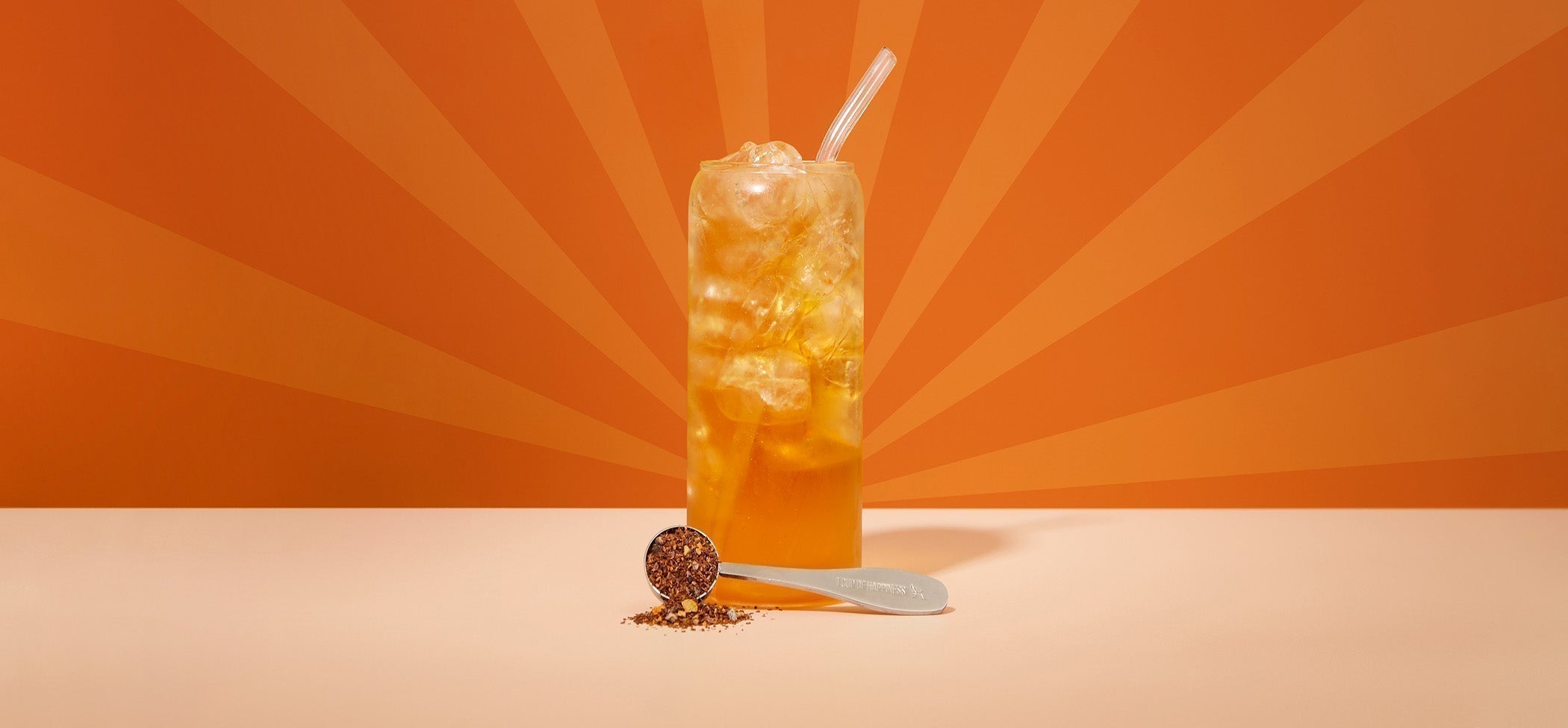 Orange golden egg shimmer caffeine free iced spritz tea in tall glass and spoon