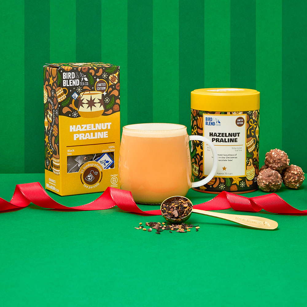 hazelnut praline tea bag gift and hot tea latte and spoon filled with loose leaf tea and hazelnut praline