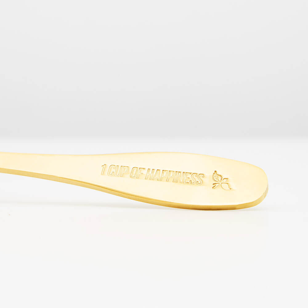 gold tea spoon with loose leaf tea