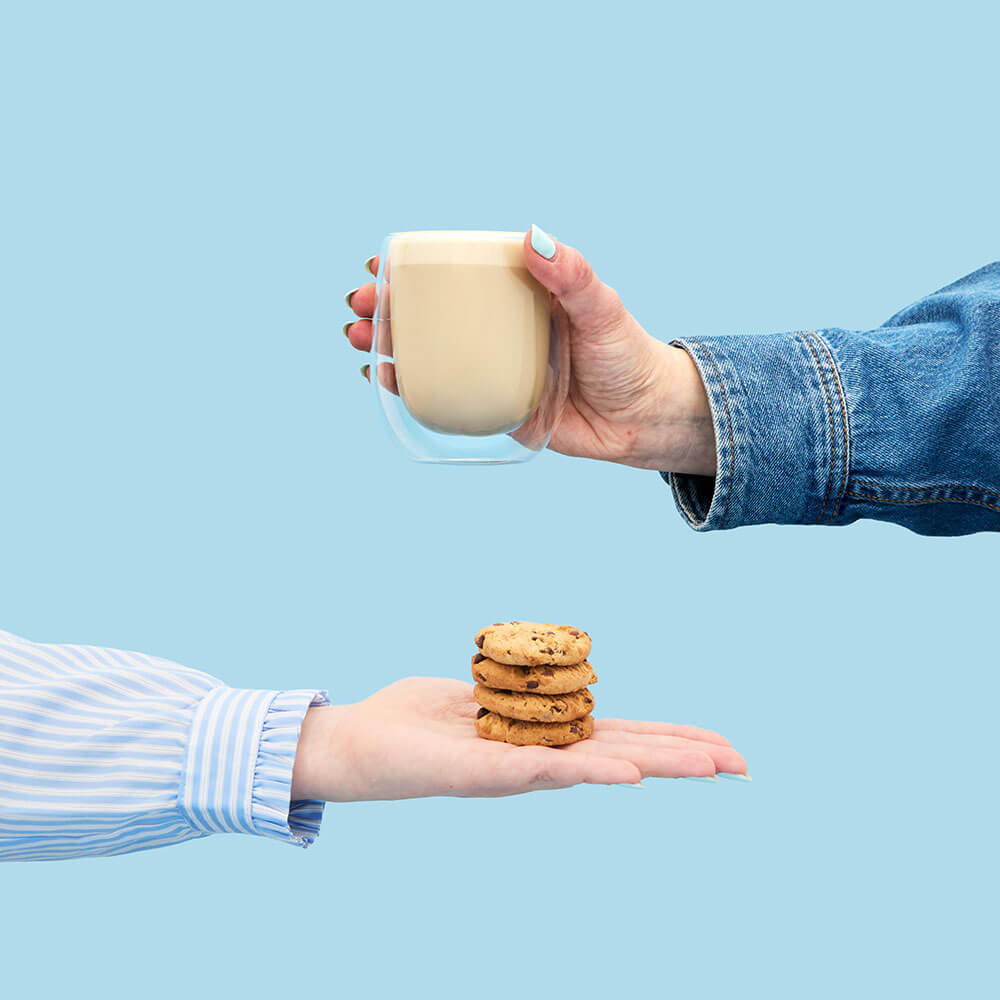 hand holding cookie hojicha tea powder hot latte in mug &amp; cookie