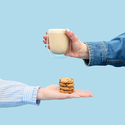 hand holding cookie hojicha tea powder hot latte in mug &amp; cookie