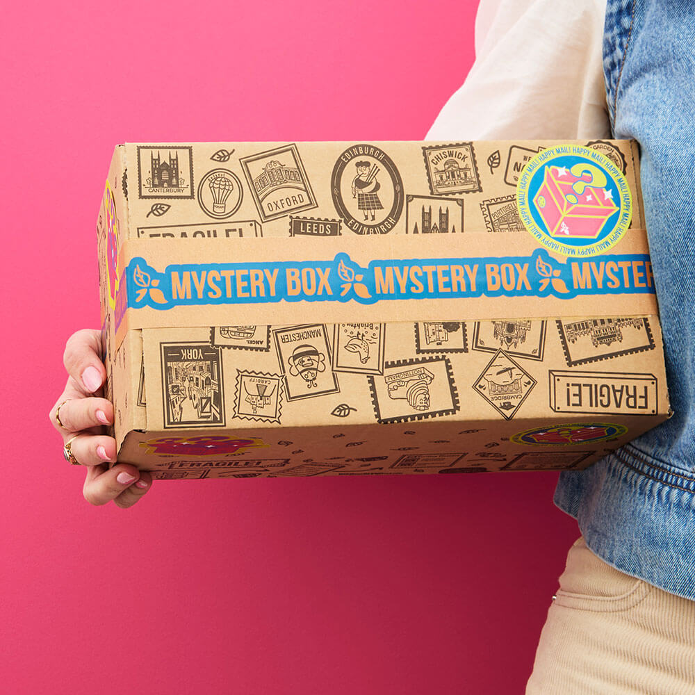 person holding mystery tea box with a pink background