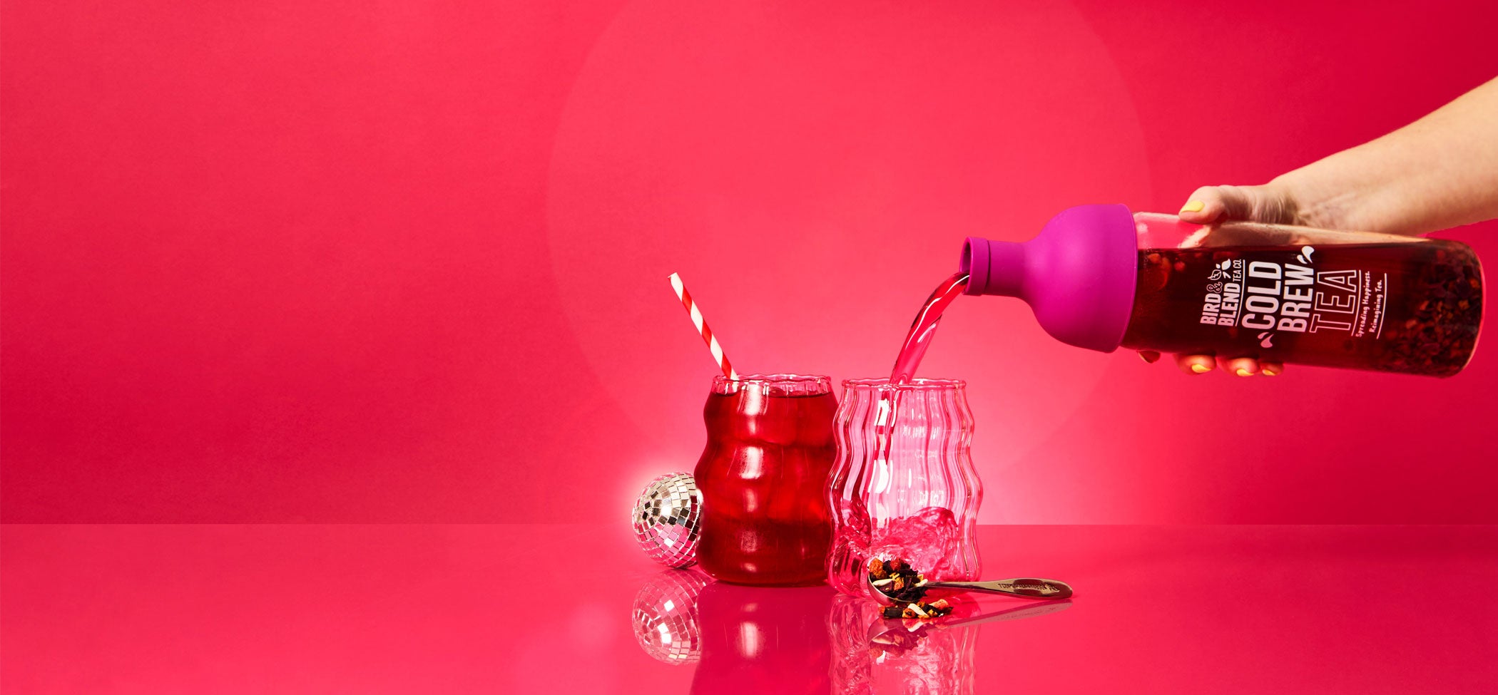 plum purple cold brew tea bottle pouring bubble gum pop! tea into glass with ice in it